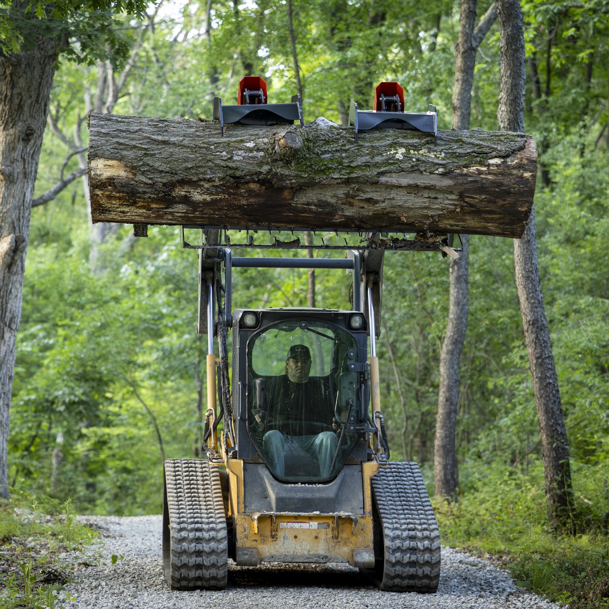 Grapple lifting a large log overhead