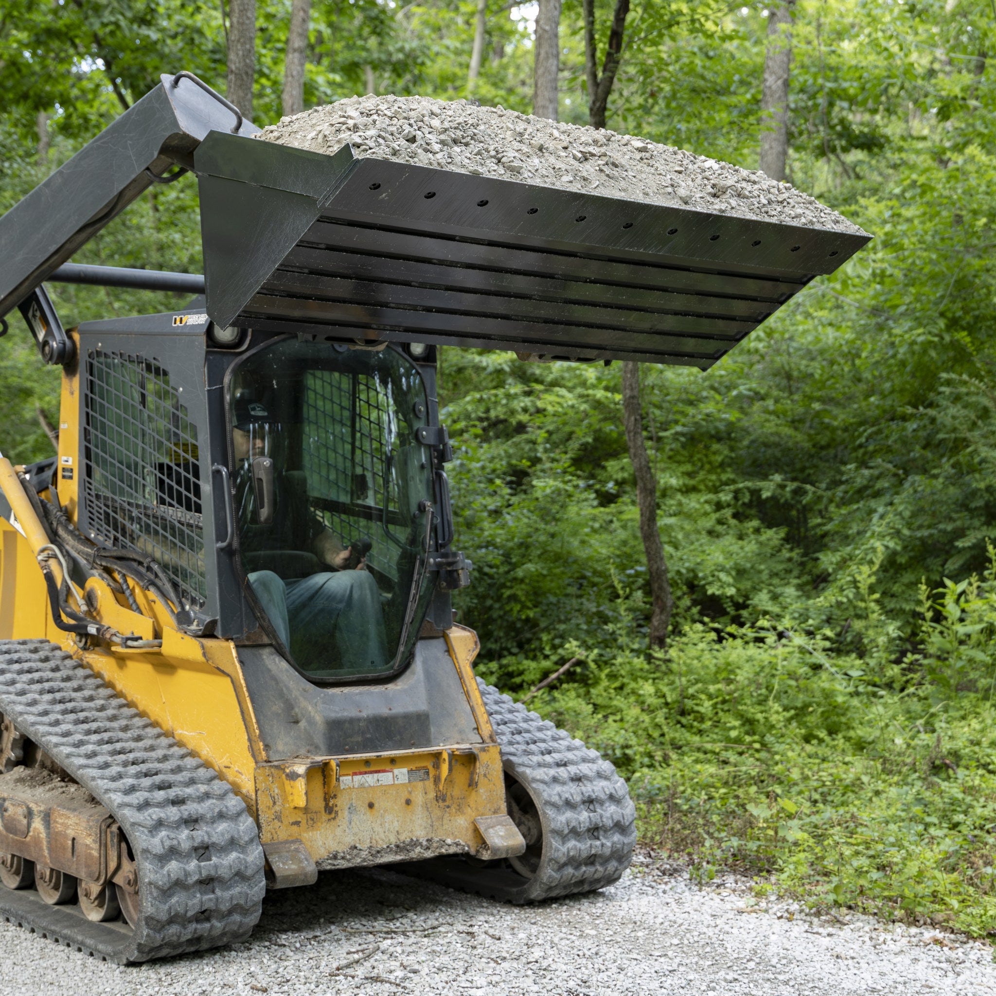 Standard bucket raised with a full load of gravel