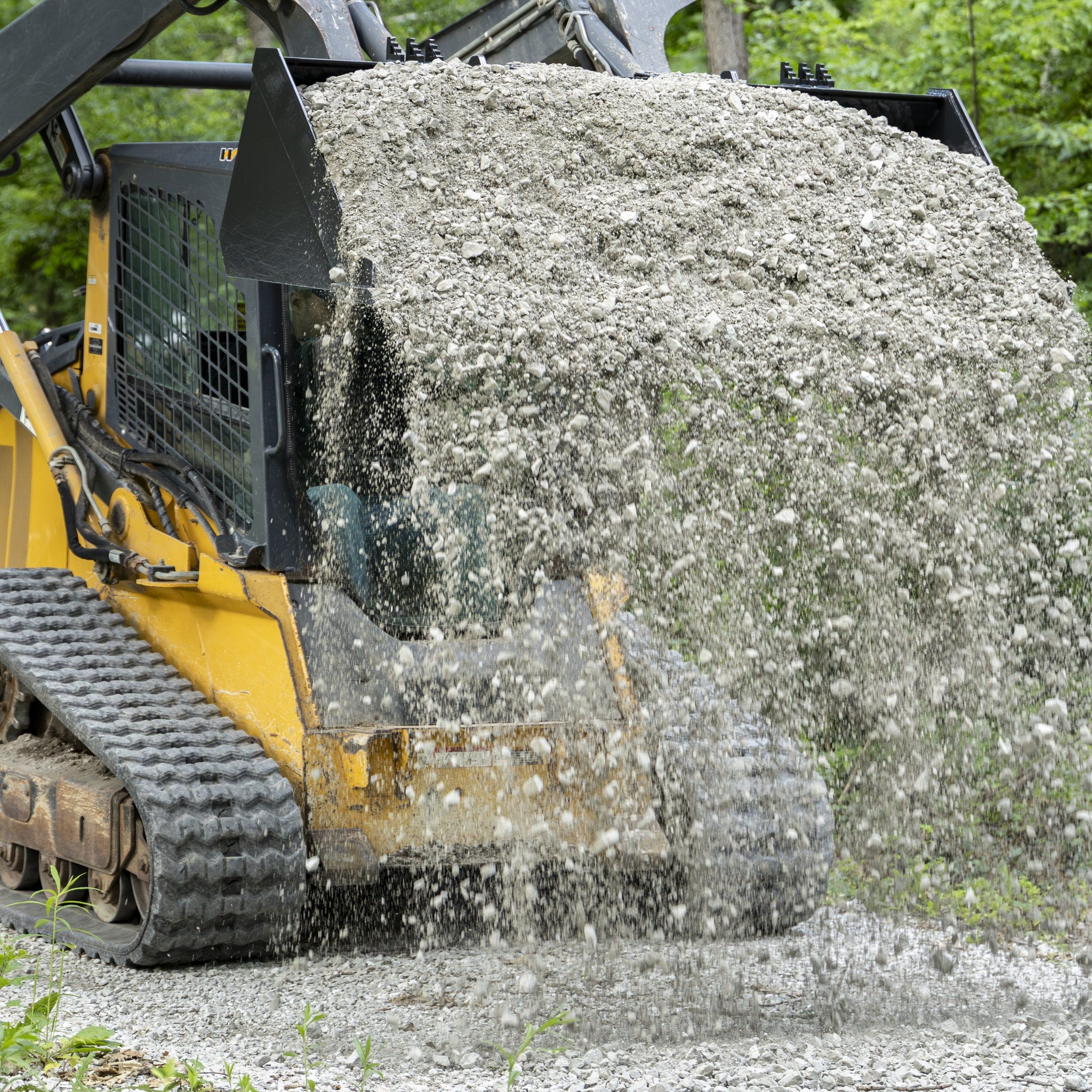 Skid steer bucket dumping gravel